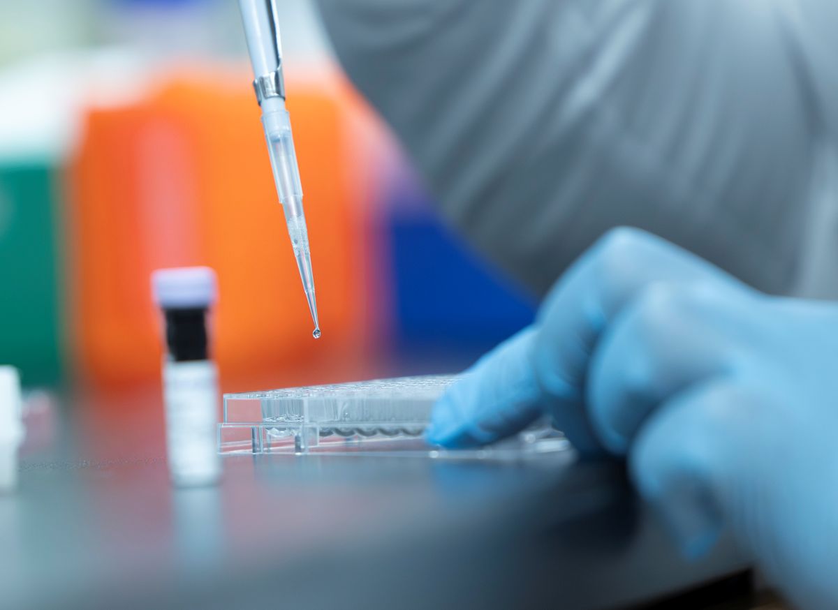 blue gloved hands pipetting